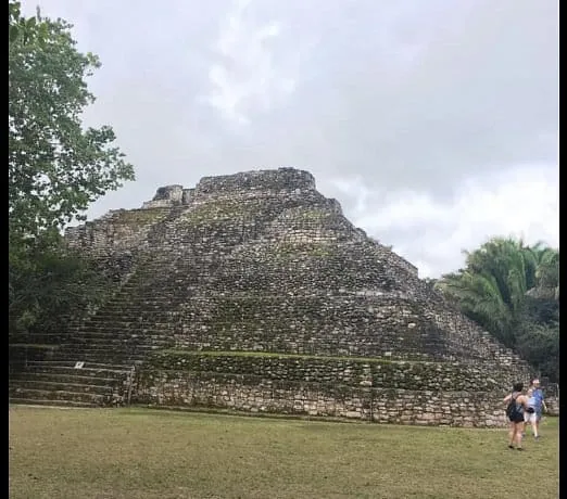 Chacchoben Mayan pyramid with a visitor at its base, Costa Maya
