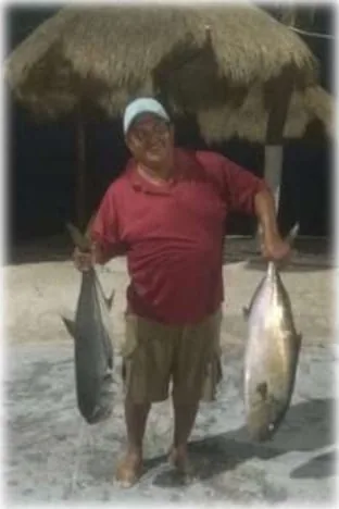 Captain holding two tuna caught on a deep sea fishing trip from Mahahual