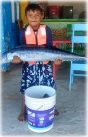 Young angler proudly holding a kingfish caught in Mahahual