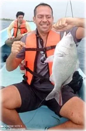 Guest holding a snapper caught on board off the Mahahual reef