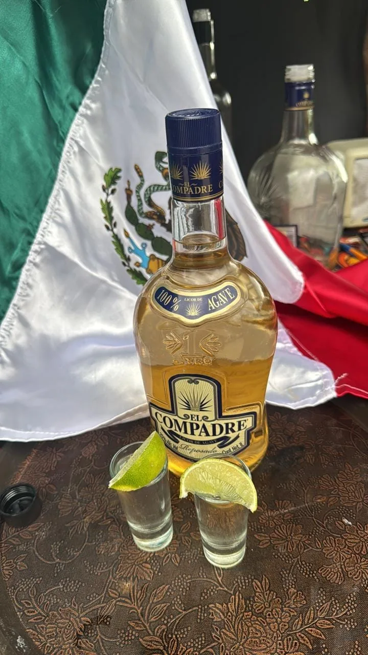 Bottle of 100% agave tequila with lime shots and the Mexican flag