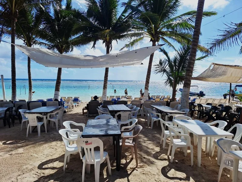Tables set on the sand at our beachfront restaurant in Mahahual